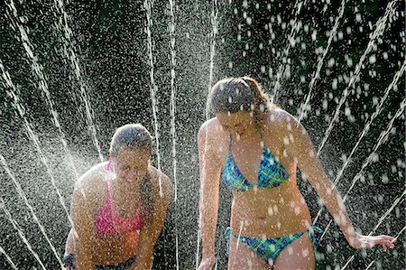 rociador - Teenage girls playing in sprinkler Foto de stock - Sin royalties Premium, Código: 614-06625295