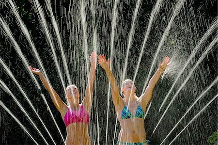 simsearch:614-08329177,k - Teenage girls playing in sprinkler Stock Photo - Premium Royalty-Free, Code: 614-06625293