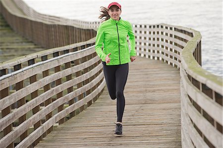 Woman running on wooden dock Foto de stock - Sin royalties Premium, Código: 614-06625318