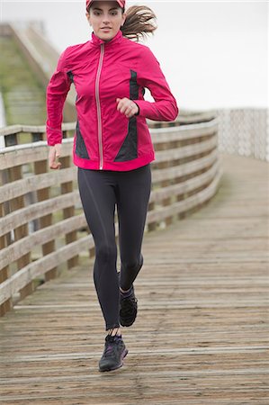 runners - Woman running on wooden dock Stock Photo - Premium Royalty-Free, Code: 614-06625313