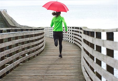 schlängeln - Woman running under umbrella Stockbilder - Premium RF Lizenzfrei, Bildnummer: 614-06625321