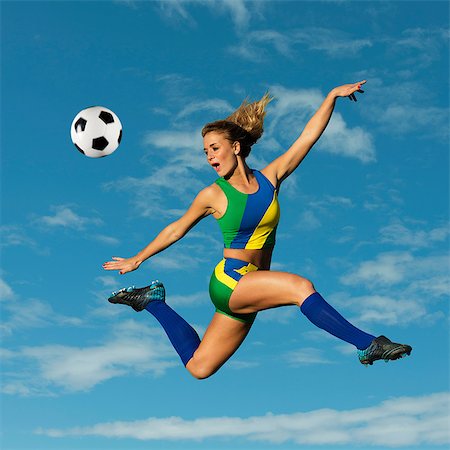 Soccer player kicking in mid-air Fotografie stock - Premium Royalty-Free, Codice: 614-06625332