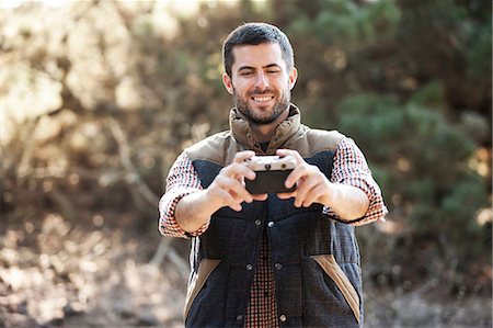 photographers - Man taking picture of himself outdoors Stock Photo - Premium Royalty-Free, Code: 614-06625393