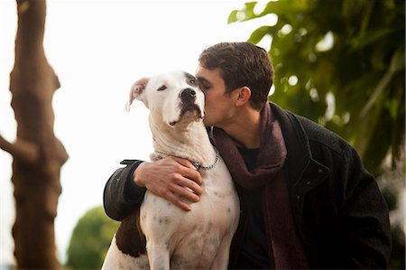 Man kissing dog outdoors Photographie de stock - Premium Libres de Droits, Code: 614-06625436
