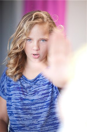 preteen portrait - Girl holding hand out to stop Stock Photo - Premium Royalty-Free, Code: 614-06623431