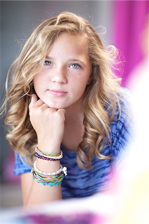 preteen blond - Smiling girl with chin in hand Stock Photo - Premium Royalty-Free, Code: 614-06623433