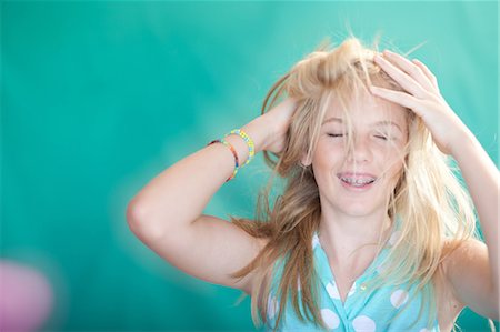 preteen girl arms raised - Teenage girl tossing her hair Stock Photo - Premium Royalty-Free, Code: 614-06623451