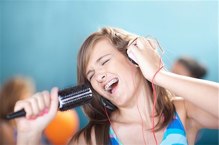 singing - Teenage girl singing into hairbrush Photographie de stock - Premium Libres de Droits, Code: 614-06623453