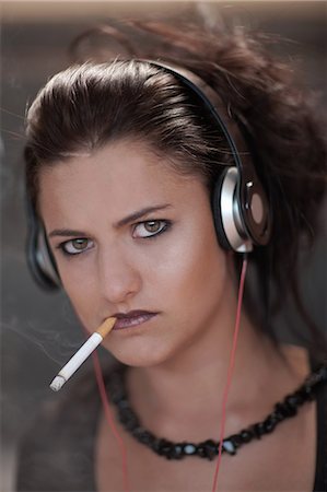 Teenage girl in dark makeup smoking Stock Photo - Premium Royalty-Free, Code: 614-06623596