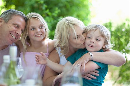 family lunch in home - Mother kissing son at table outdoors Stock Photo - Premium Royalty-Free, Code: 614-06623613