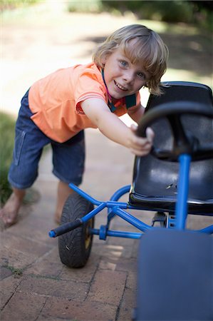 Boy pushing go kart outdoors Stock Photo - Premium Royalty-Free, Code: 614-06623673