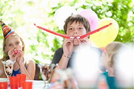 patio party day - Children blowing noisemakers at party Stock Photo - Premium Royalty-Free, Code: 614-06623758