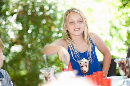 person eating ice cream - Girl having ice cream sundae at party Stock Photo - Premium Royalty-Free, Code: 614-06623760