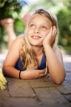 Girl laying on ground outdoors Stock Photo - Premium Royalty-Free, Code: 614-06623778