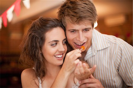 photo of a woman feeding her husband food - Couple tasting olives in grocery Foto de stock - Sin royalties Premium, Código: 614-06623827