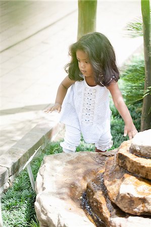 Girl climbing on stone fountain Stock Photo - Premium Royalty-Free, Code: 614-06623908