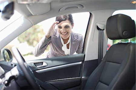 person peeking in car - Woman examining new car Stock Photo - Premium Royalty-Free, Code: 614-06623953
