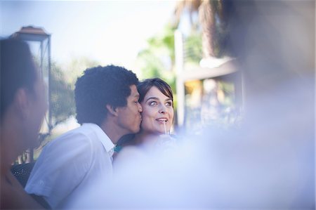 dîner entre amis - Man kissing girlfriend at table outdoors Photographie de stock - Premium Libres de Droits, Code: 614-06623996