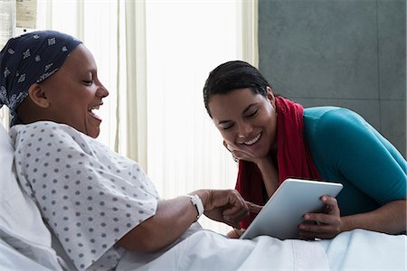 simsearch:614-06718046,k - Daughter visiting mother in hospital, showing her digital tablet Stock Photo - Premium Royalty-Free, Code: 614-06718038