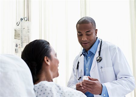 simsearch:614-08030611,k - Doctor talking to patient in hospital, looking at medicine Stock Photo - Premium Royalty-Free, Code: 614-06718044