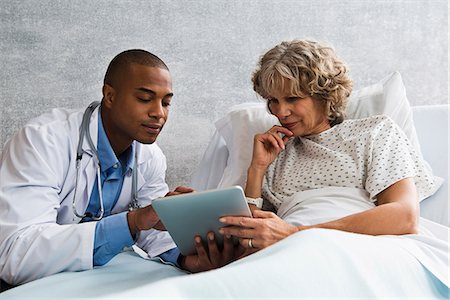 doctor with patient - Doctor showing digital tablet to patient in hospital Photographie de stock - Premium Libres de Droits, Code: 614-06718072