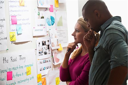 probleme - Colleagues looking at adhesive notes and paper on wall Foto de stock - Sin royalties Premium, Código: 614-06718087