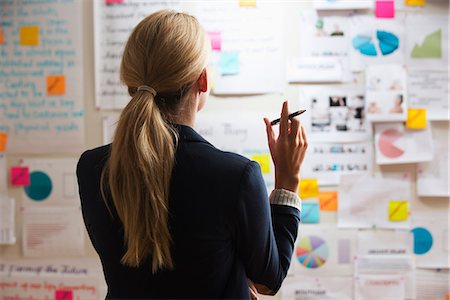 paper people - Woman holding pen, rear view Stock Photo - Premium Royalty-Free, Code: 614-06718082