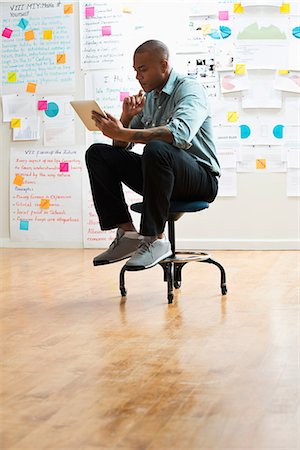 Man sitting on stool with digital tablet Stockbilder - Premium RF Lizenzfrei, Bildnummer: 614-06718103