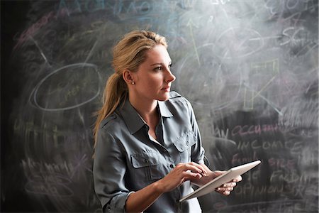 people holding chalkboards in pictures - Woman using digital tablet Stock Photo - Premium Royalty-Free, Code: 614-06718132