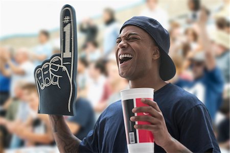 Man at sports game with foam hand and soft drink cup Foto de stock - Sin royalties Premium, Código: 614-06718166