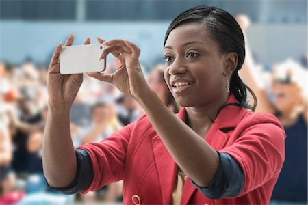 Woman in stadium, recording event with her phone Photographie de stock - Premium Libres de Droits, Code: 614-06718196