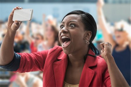 Woman in stadium, recording event with her phone Fotografie stock - Premium Royalty-Free, Codice: 614-06718198