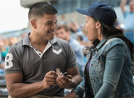 Man proposing to girlfriend at sports game Foto de stock - Royalty Free Premium, Número: 614-06718193