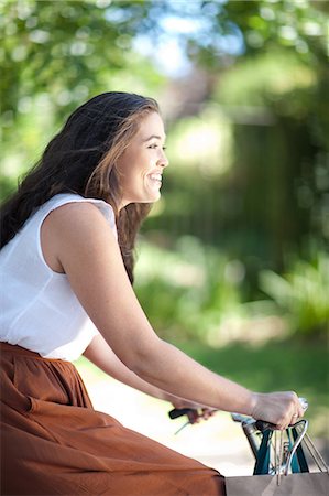 plus size woman - Woman riding bicycle in park Stock Photo - Premium Royalty-Free, Code: 614-06718275