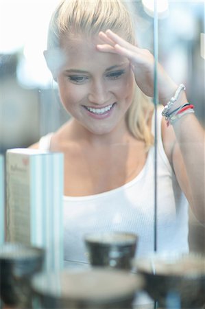 Woman looking in glass case in store Stock Photo - Premium Royalty-Free, Code: 614-06718396