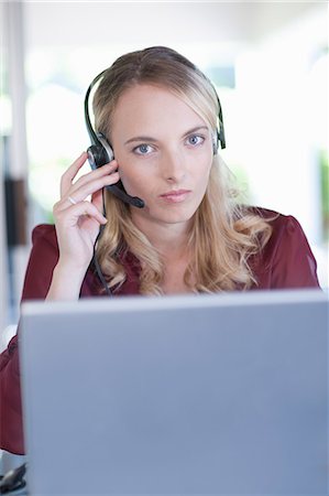 Businesswoman wearing headset at desk Stock Photo - Premium Royalty-Free, Code: 614-06718467