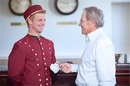 Older man tipping bellhop in lobby Foto de stock - Sin royalties Premium, Código: 614-06718558