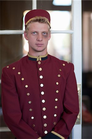 Bellhop with black eye in hotel lobby Stock Photo - Premium Royalty-Free, Code: 614-06718564