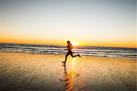 female runner side view - Woman running on beach Stock Photo - Premium Royalty-Free, Code: 614-06718839