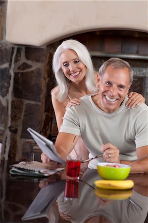 simsearch:614-06718875,k - Older couple smiling at breakfast Foto de stock - Royalty Free Premium, Número: 614-06719056