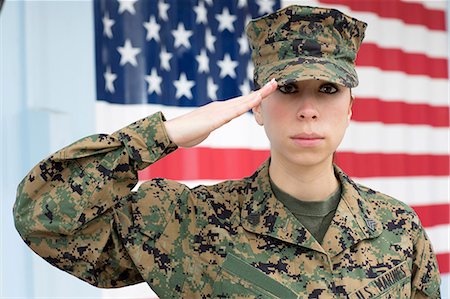 saudando - Servicewoman in camouflage by US flag Foto de stock - Royalty Free Premium, Número: 614-06719177