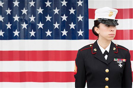 Servicewoman in dress blues by US flag Foto de stock - Royalty Free Premium, Número: 614-06719170