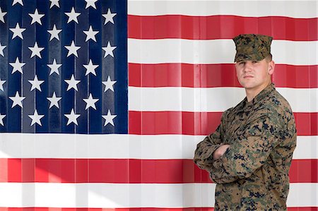 Serviceman in camouflage by US flag Foto de stock - Sin royalties Premium, Código: 614-06719181