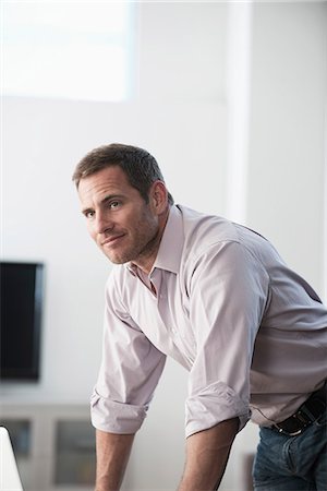 standing man - Businessman standing at desk Stock Photo - Premium Royalty-Free, Code: 614-06719365