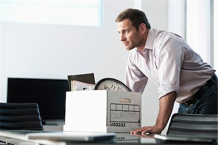 riduzione - Businessman packing up box in office Foto de stock - Sin royalties Premium, Código: 614-06719367