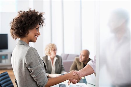 simsearch:6122-07701735,k - Business people shaking hands in office Fotografie stock - Premium Royalty-Free, Codice: 614-06719385