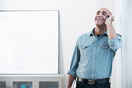 person answering phone in office - Businessman talking on cell phone Stock Photo - Premium Royalty-Free, Code: 614-06719467