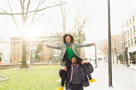 park sidewalk - Man carrying girlfriend on shoulders Stock Photo - Premium Royalty-Free, Code: 614-06719571