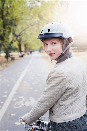 Woman on bicycle in urban park Stock Photo - Premium Royalty-Free, Code: 614-06719645
