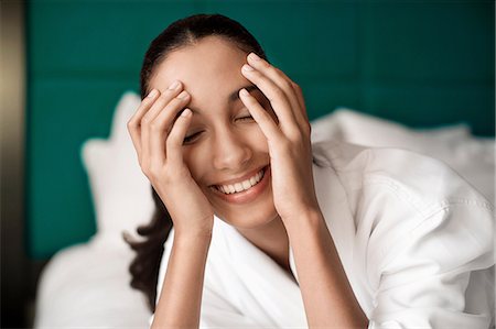 pretty teen lying down - Woman in bathrobe smiling on bed Stock Photo - Premium Royalty-Free, Code: 614-06719649